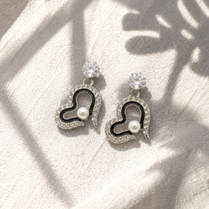 Pearl heart drop earrings with crystal detailing and silver-tone finish on white background