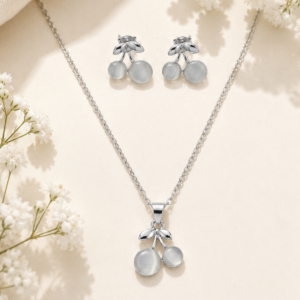 Silver cherry jewelry set with matching pendant necklace and earrings featuring luminous stone accents