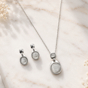 Silver pendant jewelry set with matching necklace and earrings featuring luminous stone-inspired accents
