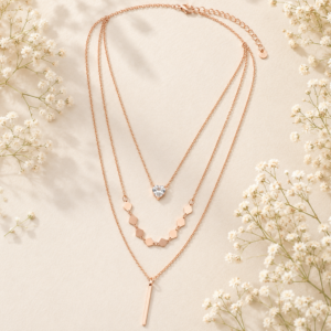 Women's rose gold layered necklace with heart crystal pendant and geometric chain details.