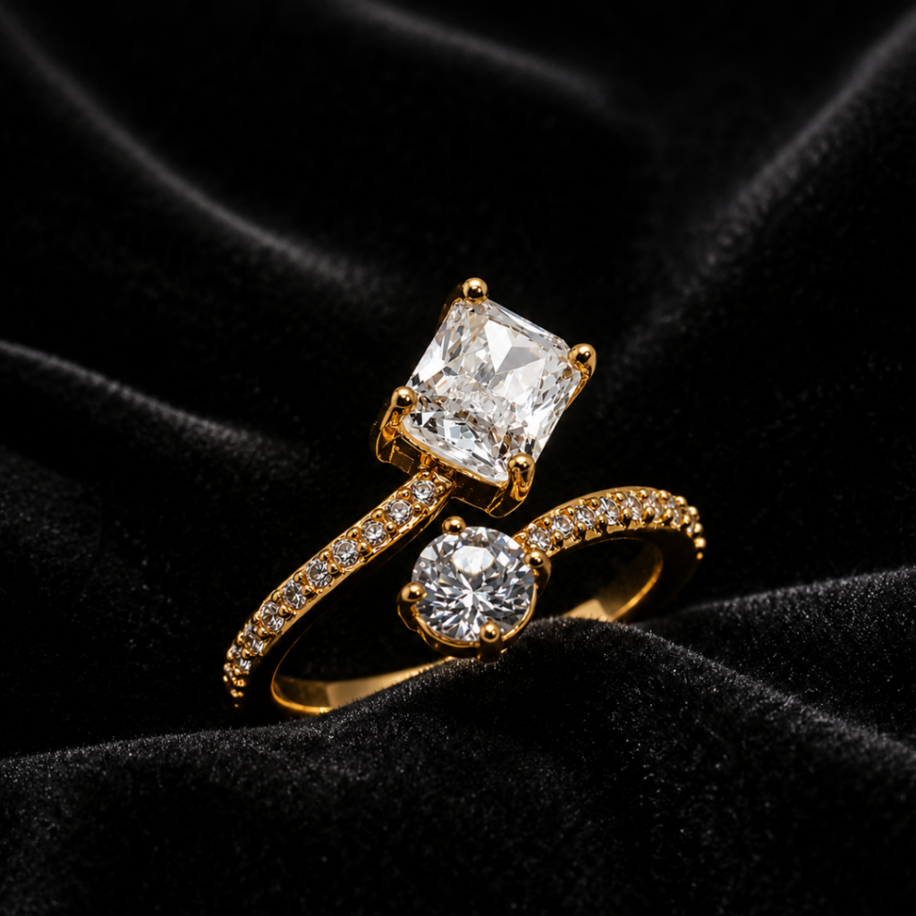 Tavielle gold ring featuring a rectangular radiant cut center stone and a round accent crystal in a paved bypass band
