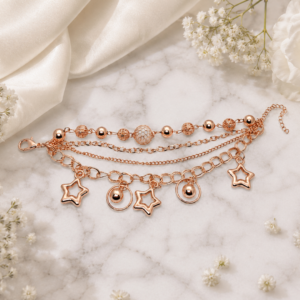 Tavielle multi-strand rose gold bracelet featuring textured metallic spheres and open star charms